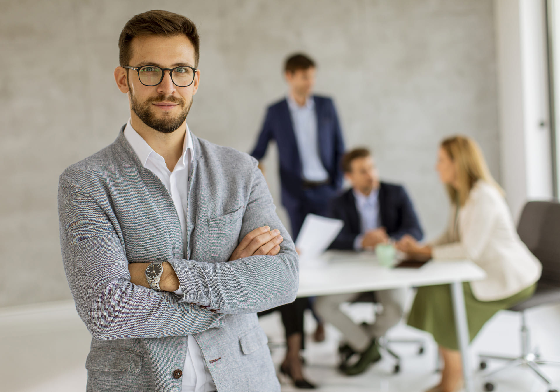 man-in-glasses-posed-with-team-in-the-background